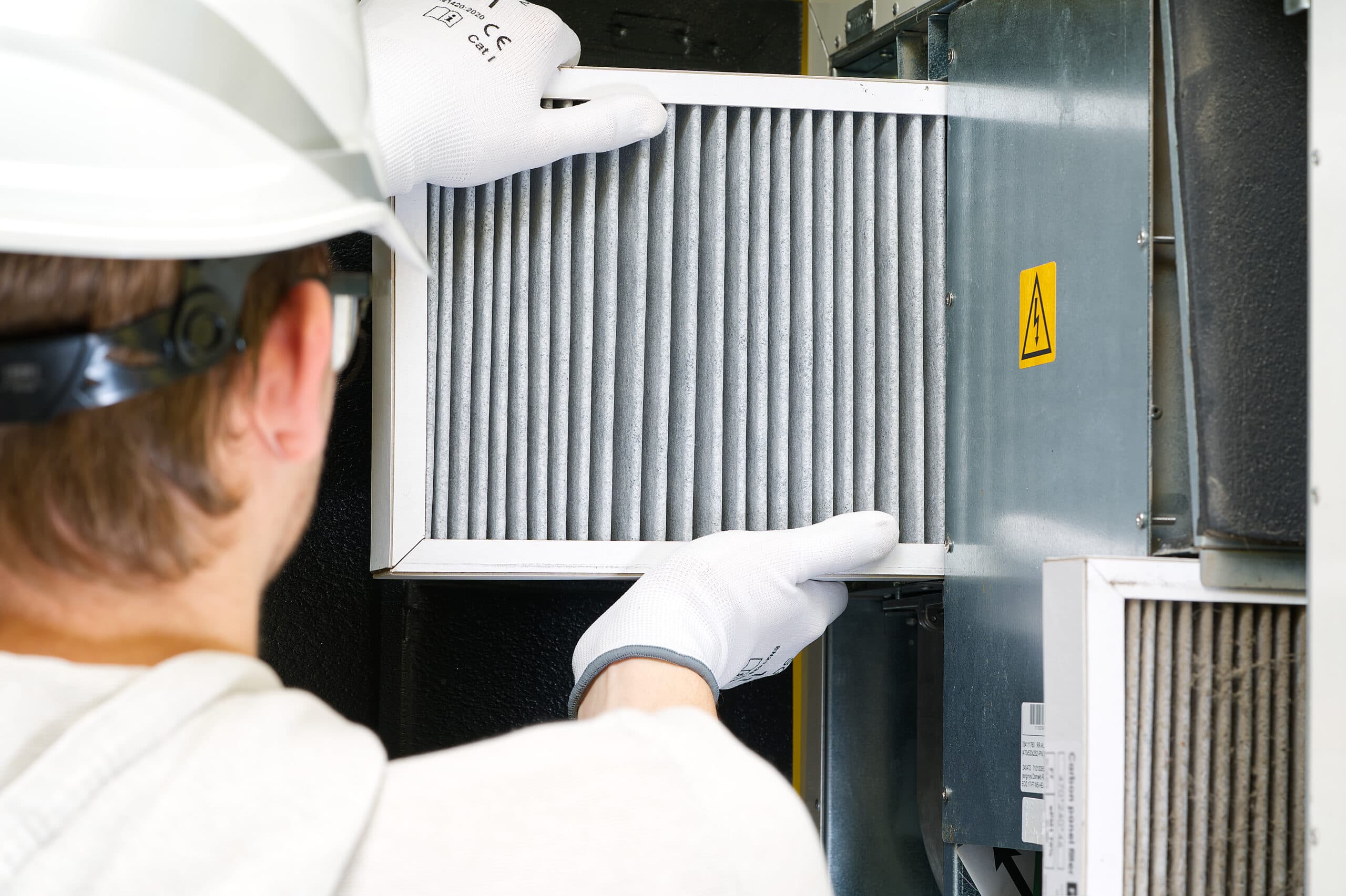 Technician replacing a home HVAC air filter